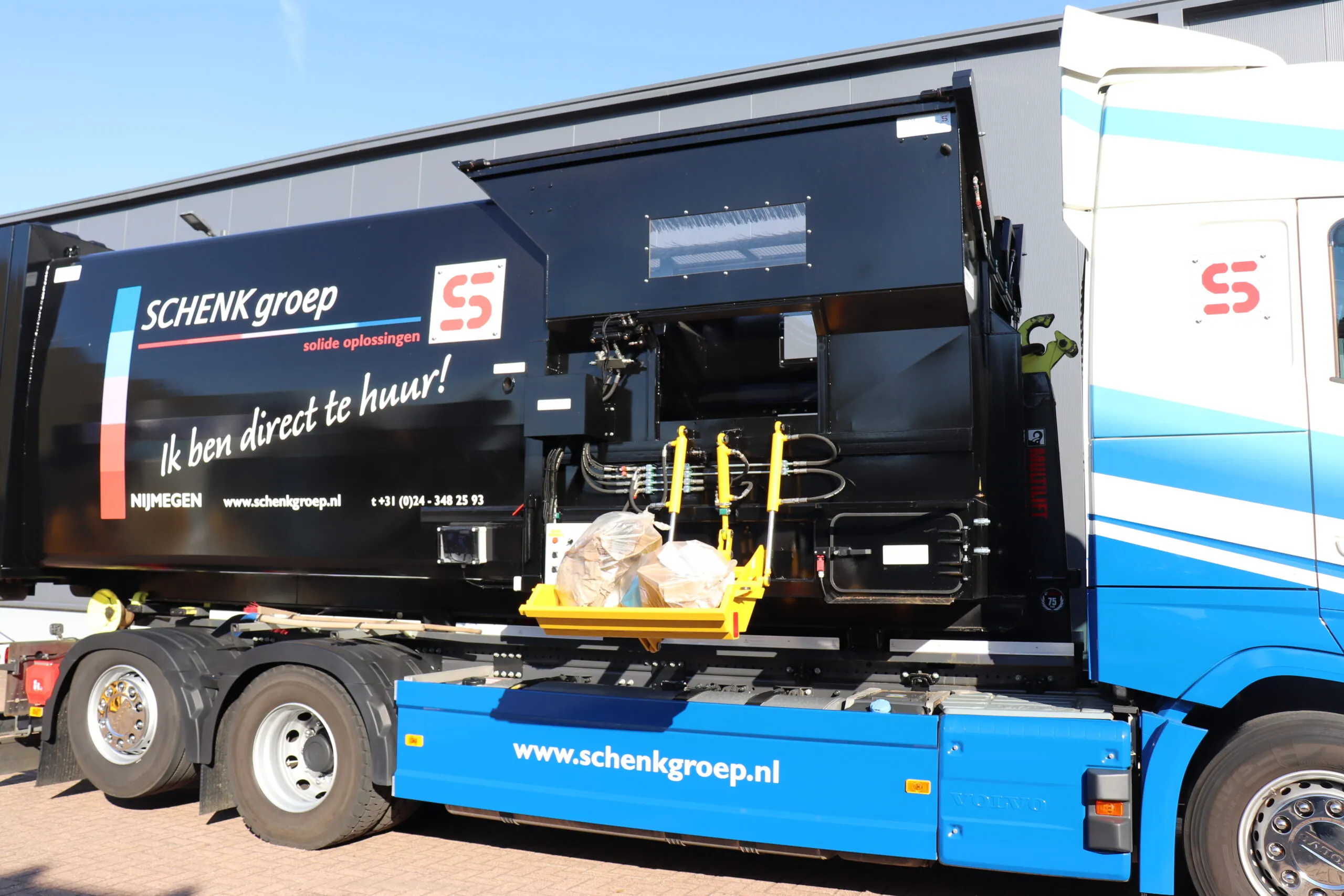 Vrachtwagen van SCHENK Groep met IPC-afvalpersunit, voorzien van branding en contactgegevens, klaar voor directe verhuur