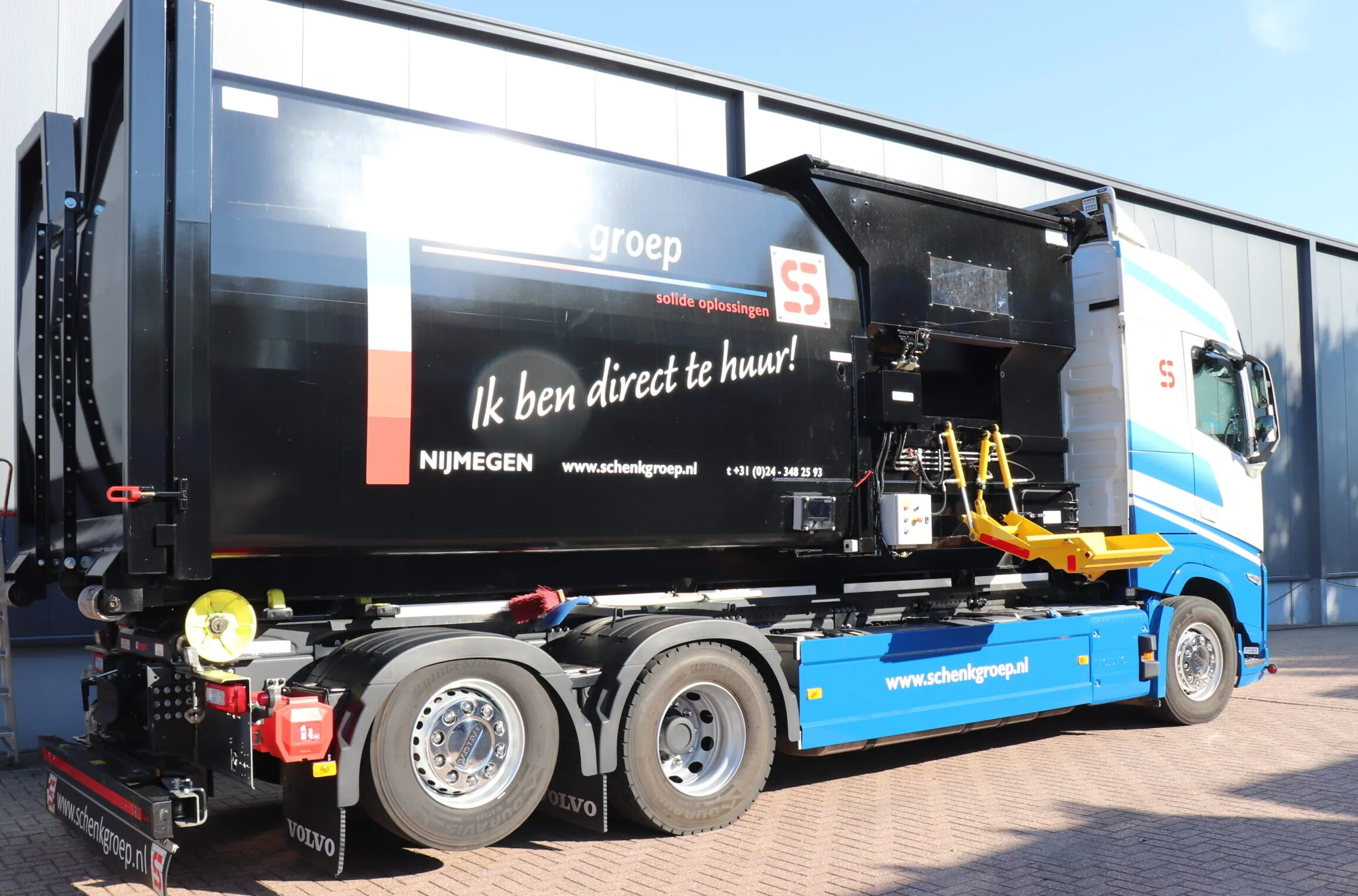 Zijkant van een SCHENK Groep truck met hydraulische installatie en branding, klaar voor industriële toepassingen en verhuur